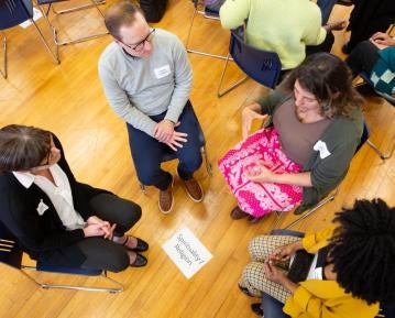 attendees sit on the floor in group discussion